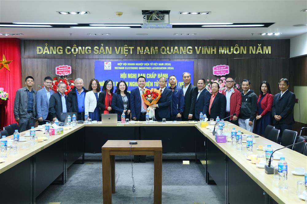 Tiến sĩ Nguyễn Văn Đ&ocirc;ng, Chủ tịch VEIA (giữa), nhận hoa ch&uacute;c mừng từ Ph&oacute; Chủ tịch VCCI, &ocirc;ng Ho&agrave;ng Quang Ph&ograve;ng, c&ugrave;ng c&aacute;c thanh vi&ecirc;n Ban chấp h&agrave;nh VEIA mới được kiện to&agrave;n nh&acirc;n sự.